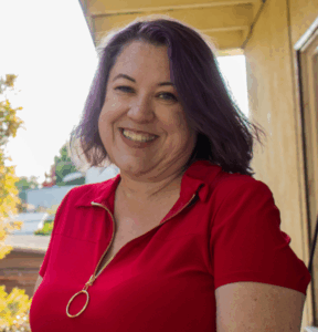Smiling woman with short hair and bright red shirt.
